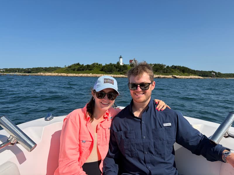 Chad and Anna on a boat by a Cape Cod lighthouse